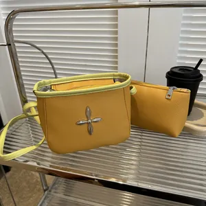 Vue détaillée de l'ensemble sac seau jaune moutarde avec bordure vert citron et croix métal