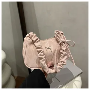 Detail of pink marble textured shoulder bag with metallic bow and ruched handle