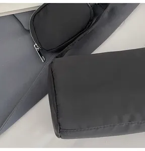 Close-up of black nylon shoulder bag with silver zipper and small attached coin purse
