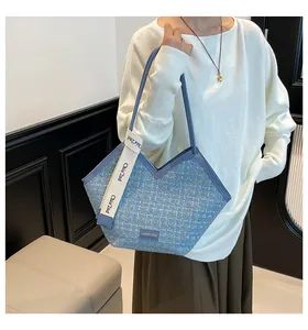 Detail of blue tweed tote bag with leather trim and branded decorative woven strap