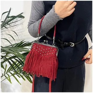 Detail of red suede tassel shoulder bag with metallic studs and vintage frame closure