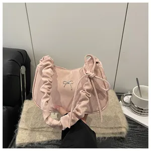 Detail of pink pleated handle bag with silver butterfly buckle and side ribbon knot