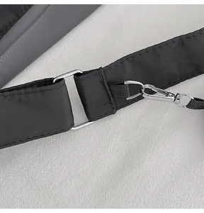 Close-up of black nylon shoulder bag strap with silver metal lobster clasp hardware