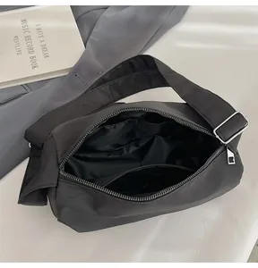 Detail view of large black nylon crossbody bag interior with zipper and inner pocket