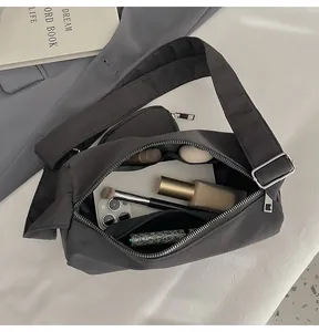 Macro view of the spacious internal compartments and black nylon lining of the crossbody bag
