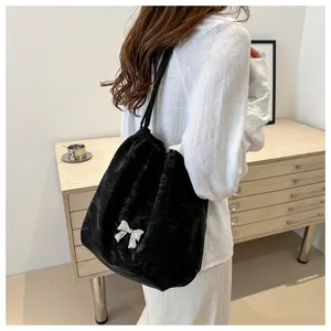Close-up of black velvet drawstring bag with a polished silver butterfly buckle detail