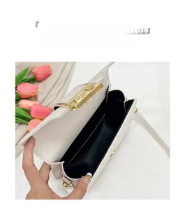 Macro detail of white quilted shoulder bag showing interior lining and gold metal lock