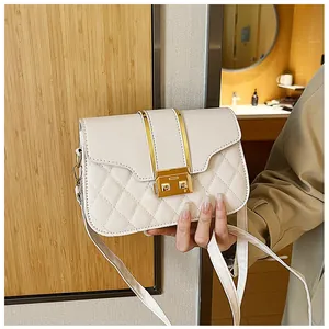 Detail of beige quilted shoulder bag with gold square buckle and leather strap