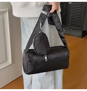 Detail of black nylon cylinder bag with wide strap and detachable round coin purse