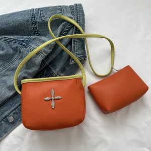 Sac seau orange avec détail étoile croisée et bandoulière vert citron sur denim