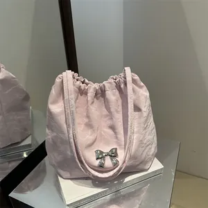 Pink pleated drawstring handbag with a silver butterfly charm and chain shoulder strap