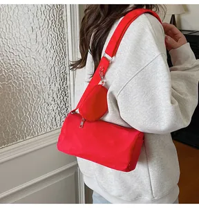 Detail view of red nylon crossbody toast bag with small round coin purse on shoulder strap