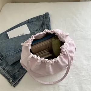 Pink drawstring bucket bag with butterfly chain and large capacity shown with accessories