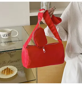 Detail of red nylon cylinder bag with wide strap and matching round coin purse