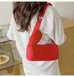Detail of red nylon crossbody toast bag with a matching mini hanging pouch on wide strap