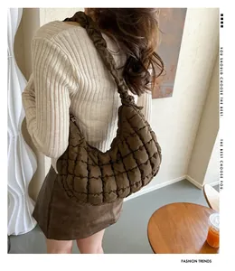 Détail du sac matelassé marron foncé montrant la texture nylon et la bandoulière froncée