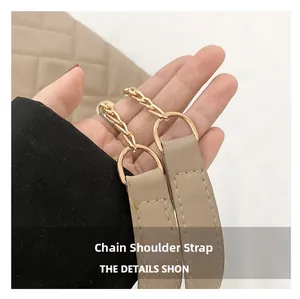 Detail of the light khaki PU leather strap with golden metal chain on a quilted tote bag