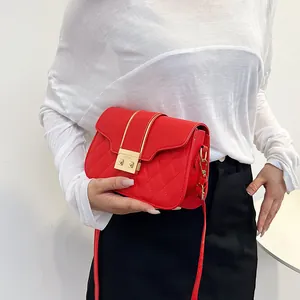 Fashionable red quilted crossbody bag with golden hardware lock and diamond stitching