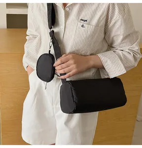 Detail of black nylon cylinder crossbody bag with matching round coin purse attachment