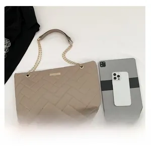 Detail view of large beige quilted tote bag showing interior space for iPad and phone