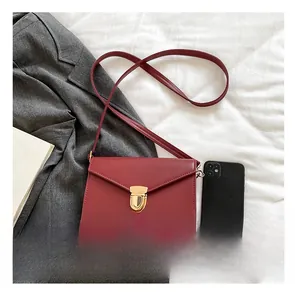Makroansicht der burgunderroten Umschlagtasche mit Metallverschluss und Größenvergleich