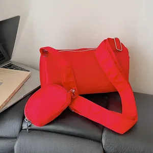 Red toast-style crossbody pillow bag with wide strap and matching round coin purse