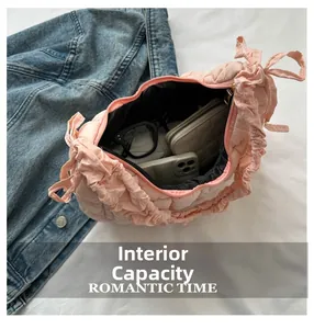 Détail du sac fourre-tout matelassé rose clair montrant l'espace pour téléphone et portefeuille