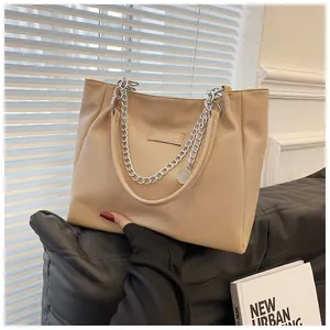 Detailed macro view of beige tote bag texture with silver chain and leather handle