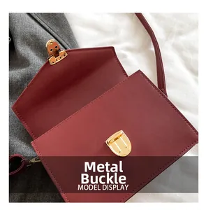 Detail der weinroten rechteckigen Klapptasche mit hochwertiger goldener Metallschnalle