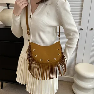 Vintage brown suede crescent tassel crossbody bag with rivet details worn by model