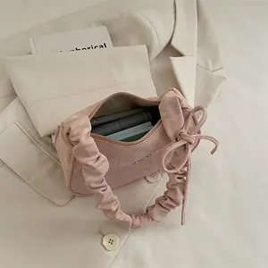 Pink ruched underarm bag with bow detail showing spacious interior storage capacity