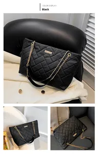 Close-up of black quilted tote bag with gold logo plate and chain shoulder strap detail