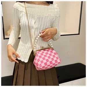 Detail of pink checkerboard knit bag with pearl handle and gold vintage clasp
