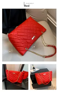 Detail view of large red quilted tote bag with golden chain strap and metal clasp