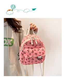 Detail showing pink corduroy mini backpack with cherry print and canvas shoulder straps