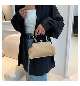Close-up of khaki faux fur mini handbag with gold metal handle and chain strap on model