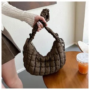 Détail d'un sac matelassé marron foncé avec anse plissée et motif à losanges vintage