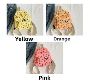 Detailed view of corduroy cherry print mini backpacks in yellow, orange, and pink colors