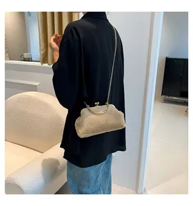 Detail showing plush beige faux fur handbag with gold chain strap worn by a model