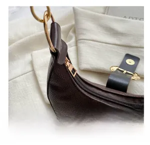 Detail of smooth gold zipper and pebble leather texture on the vintage hobo bag