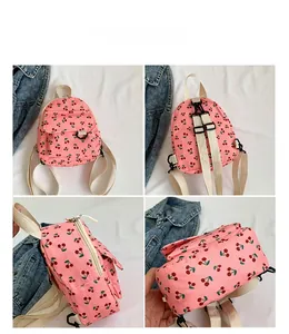 Detail view of pink corduroy mini backpack featuring cute red cherry prints and straps