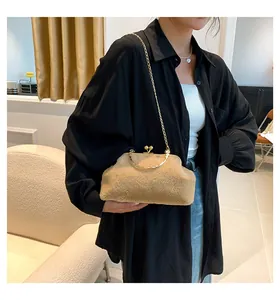 Detailed shot of camel faux fur clutch featuring gold metal frame and stylish chain strap