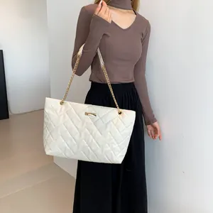 White quilted tote bag with golden chain strap and minimalist diamond pattern design