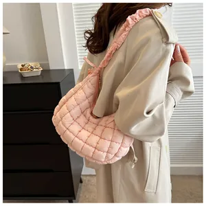 Détail du sac à bandoulière matelassé rose avec bandoulière plissée et texture douce