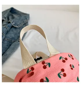 Detail of sturdy cream webbed handle on pink corduroy backpack with cherry pattern