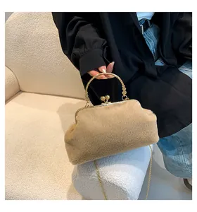 Detail of faux fur camel handbag featuring an engraved gold handle and chain strap