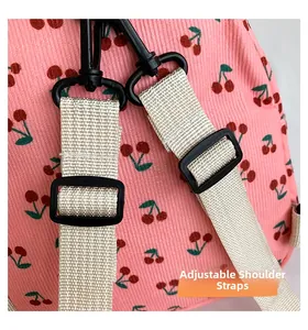 Detail of adjustable straps on pink corduroy mini backpack with cherry pattern