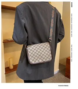 Détail du sac bandoulière vintage avec large sangle brodée et toile à motifs géométriques