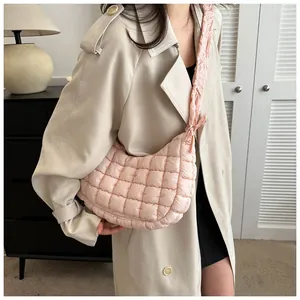 Détail du sac nuage matelassé rose clair avec motifs de losanges sur la bandoulière souple