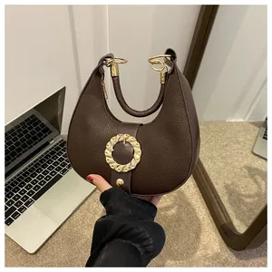 Close-up of hobo bag featuring dark brown lychee grain leather and golden metal clasp